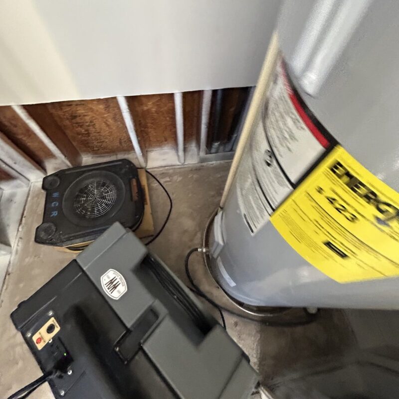 Air scrubber and air mover set up beside a water heater where the lower wall was cut open