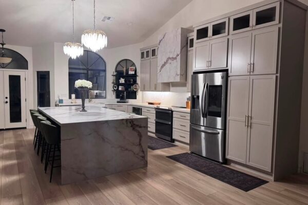 Kitchen remodel in Mesa, AZ with marble waterfall island, shaker cabinets and wood-look flooring by Western Construction & Restoration